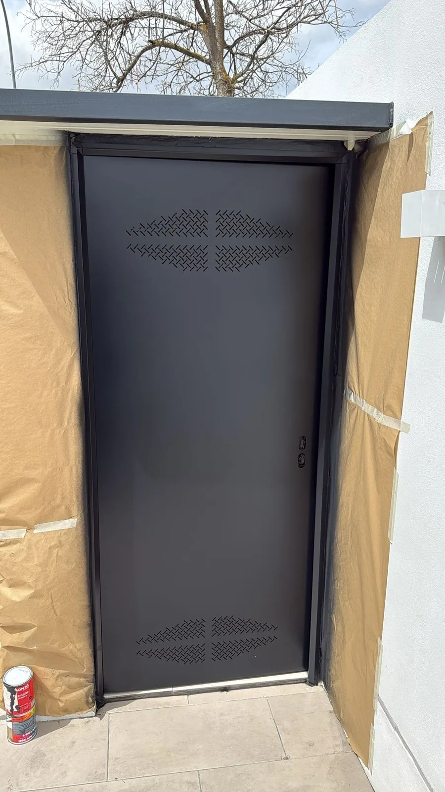 Puerta metálica lacada en negro instalada en un acceso de local en Madrid