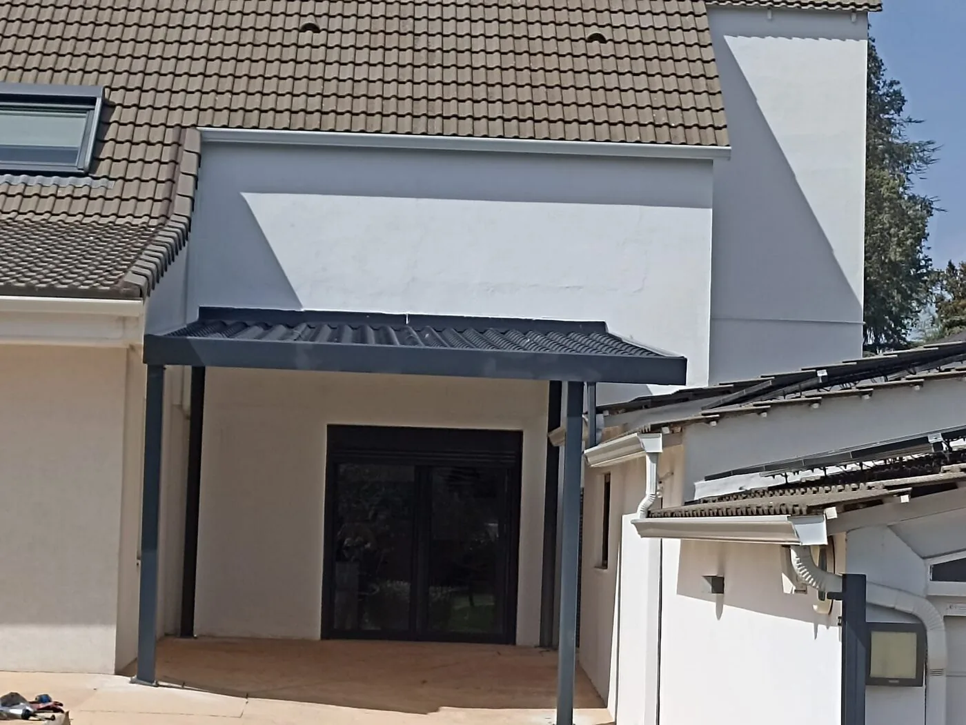 Tejadillo metálico sobre puerta de entrada de vivienda