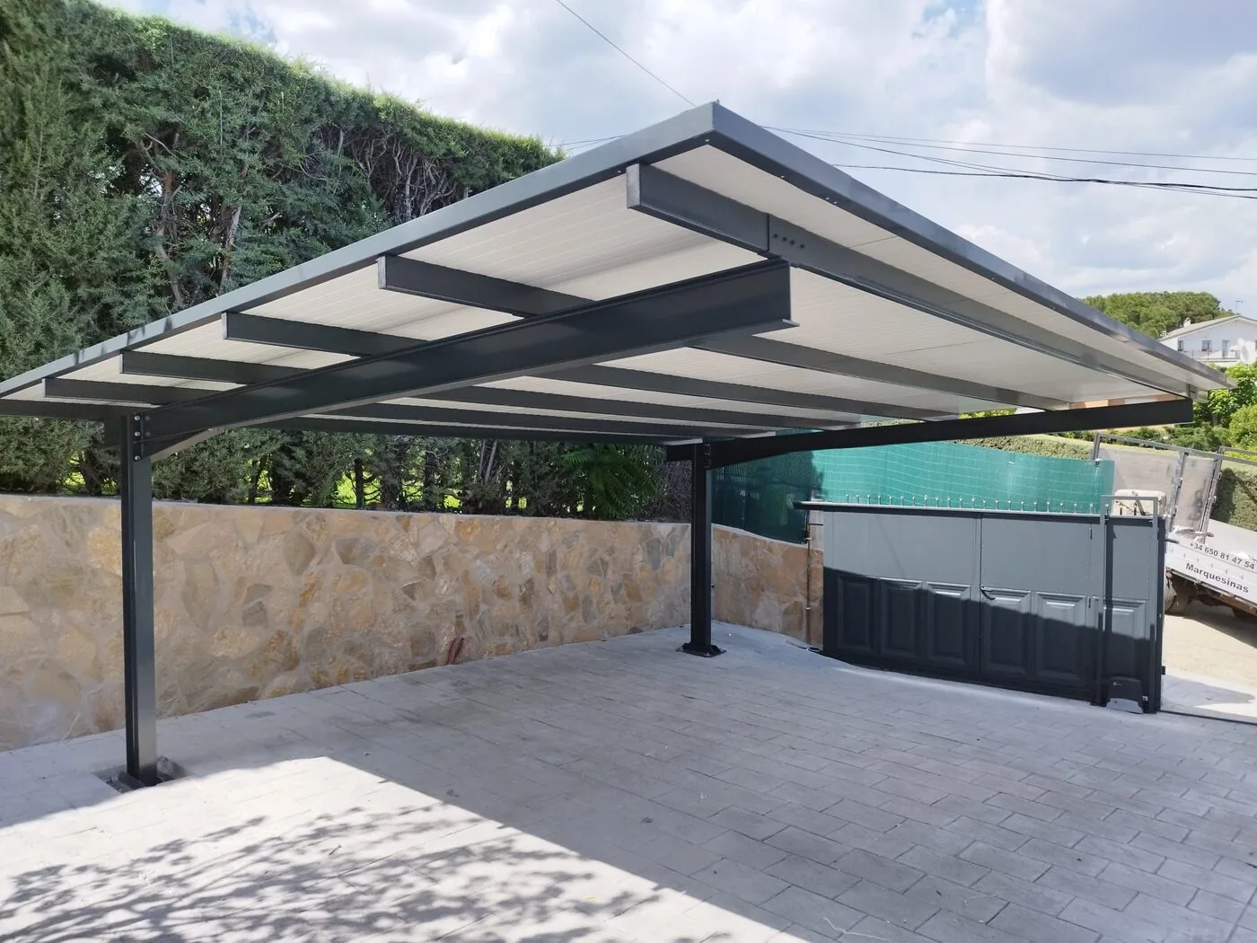 Carport con cubierta plana junto a seto verde